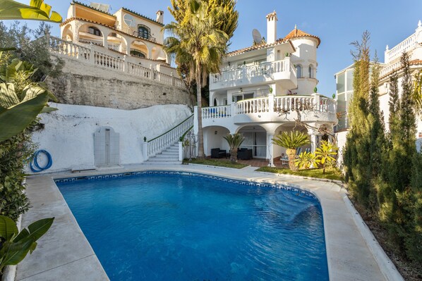 A swimming pool with a white building in the background.