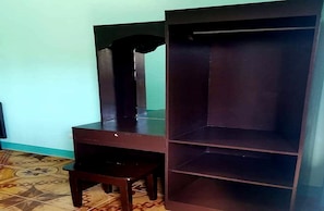 A room with a dark wooden cabinet with shelves, a small wooden stool, and a tiled floor. - OYO 833 Ln Apartelle (Butuan)