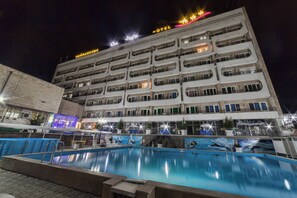A hotel with multiple balconies and a swimming pool in the foreground. - Osh Nuru (Osh)
