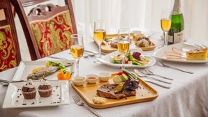 A dining table set with various dishes, glasses of wine, and a bottle of champagne. - Osh Nuru (Osh)