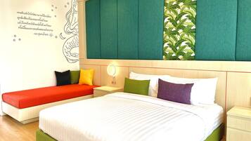 Una habitación de hotel moderna con una cama grande, un banco y una mesita de noche.