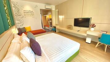 A modern bedroom with a bed, a desk, a TV, and a small bathroom.