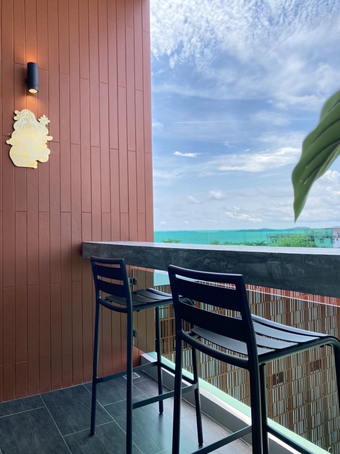 Ein Balkon mit zwei Stühlen und einer Wandleuchte.