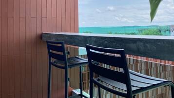 Ein Balkon mit zwei Stühlen und einer Wandleuchte.
