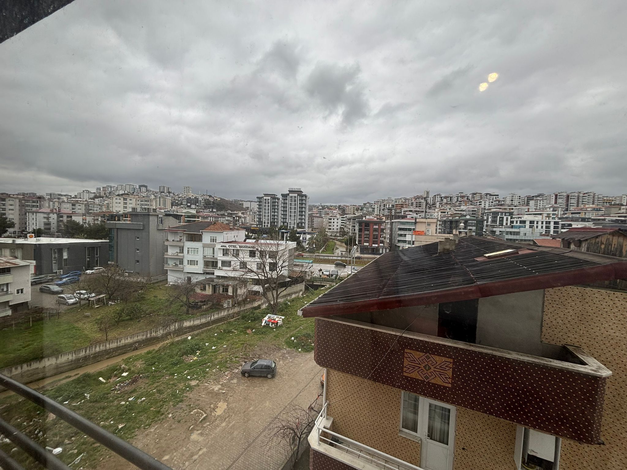 A cityscape with a view of buildings, a road, and a car.