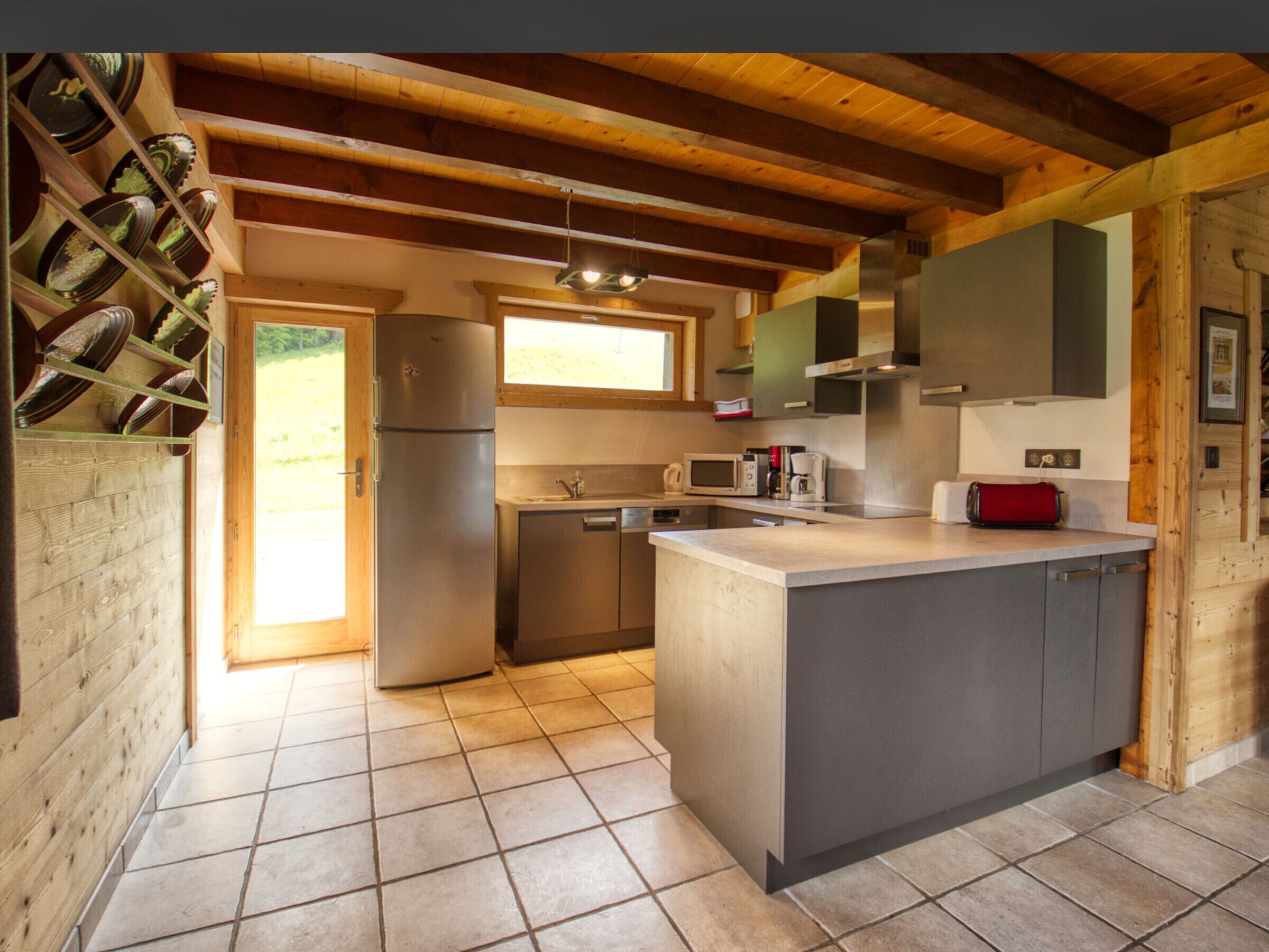 Una cucina moderna con isola centrale, elettrodomestici in acciaio inossidabile e travi in legno.