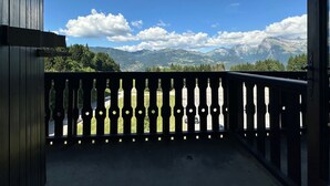 A balcony with a view of mountains and a clear sky. - Cozy mezzanine apartment in Morillon 1100 (Morillon 1100)