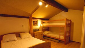 A bedroom with a bunk bed, a single bed, wooden flooring, and a ceiling light. - Charming Duplex Mezzanine in Morillon Village (Morillon Village)