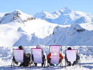 Guests can enjoy scenic mountain views from comfortable chairs with Glacier Mountain branding.