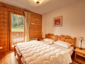 Relax in this serene bedroom with a double bed and plush duvet, accompanied by a bedside table and lamp.