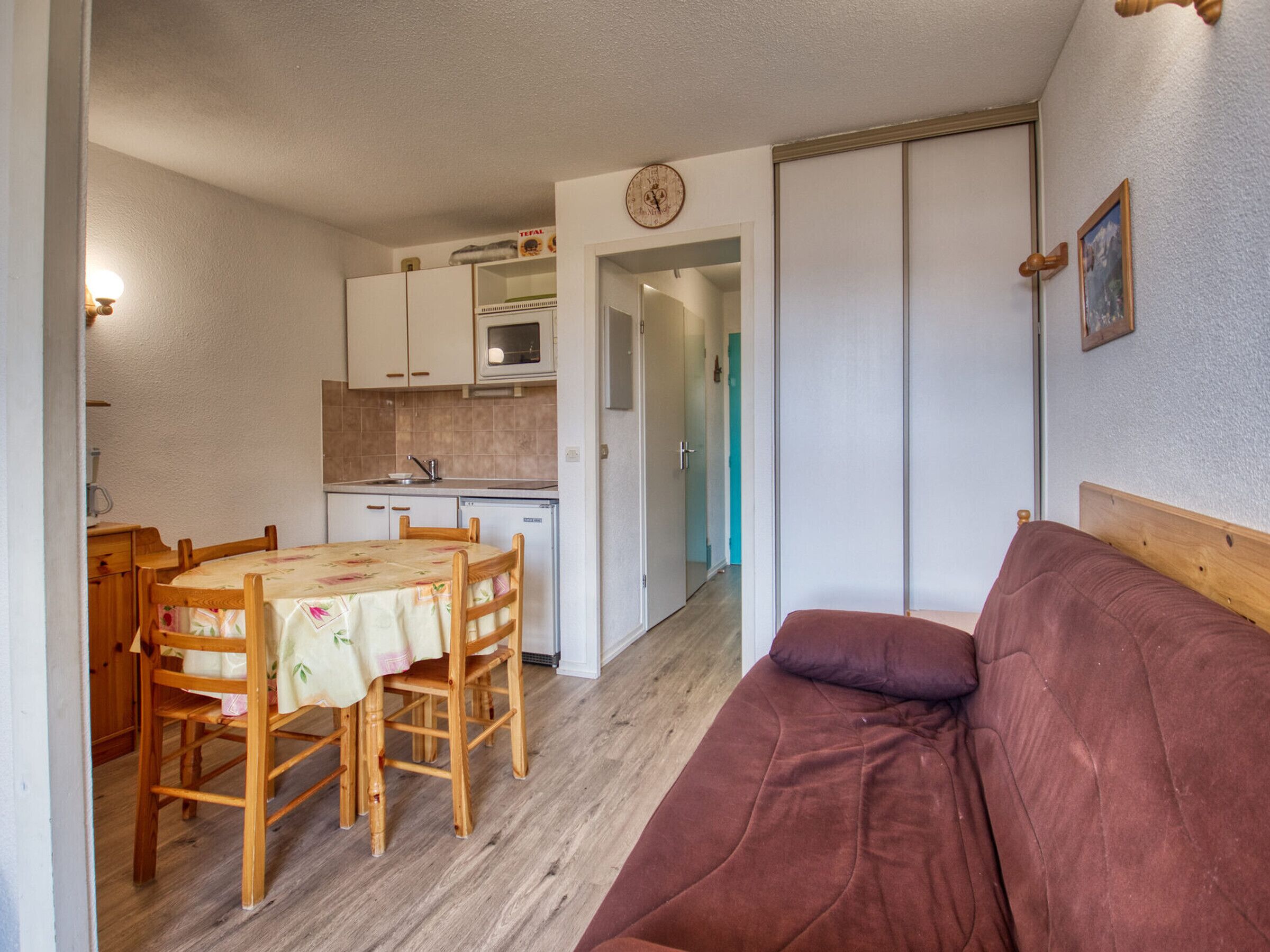 A compact living space with a kitchenette, a dining area, and a sofa.