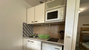 A compact kitchenette with a microwave, sink, and a small refrigerator. - Ski-in apartment for 5 people, balcony, Morillon 1100 (Morillon 1100)