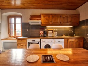 A kitchen with wooden cabinets, a dishwasher, a stove, and a sink. - Family home in Morillon, sauna and garden (Morillon Village)