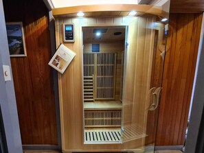 A wooden sauna with a control panel, ventilation system, and a small poster on the wall. - Family home in Morillon, sauna and garden (Morillon Village)