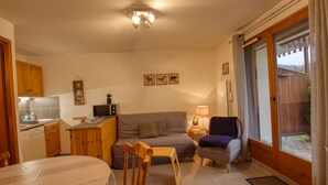 A cozy living area with a sofa, a dining table, and a kitchen in the background. - Renovated apartment near lake and shuttle, 4 pers, non-smoking, no internet (Morillon Village)
