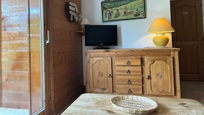 Ein Holzinnenraum mit einem Fernseher, einer Lampe und einem an der Wand befestigten Schild.