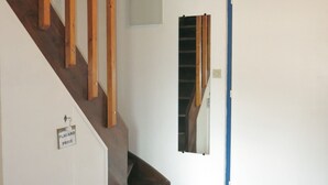 Una escalera con barandillas de madera y una puerta azul en la parte superior.