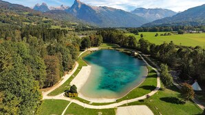 A lake surrounded by forest and mountains. - Charming apartment in renovated farmhouse, sauna & terrace (Morillon Village)