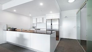 Enjoy cooking in this well-equipped kitchen with a central island, stainless steel appliances, and white cabinetry.