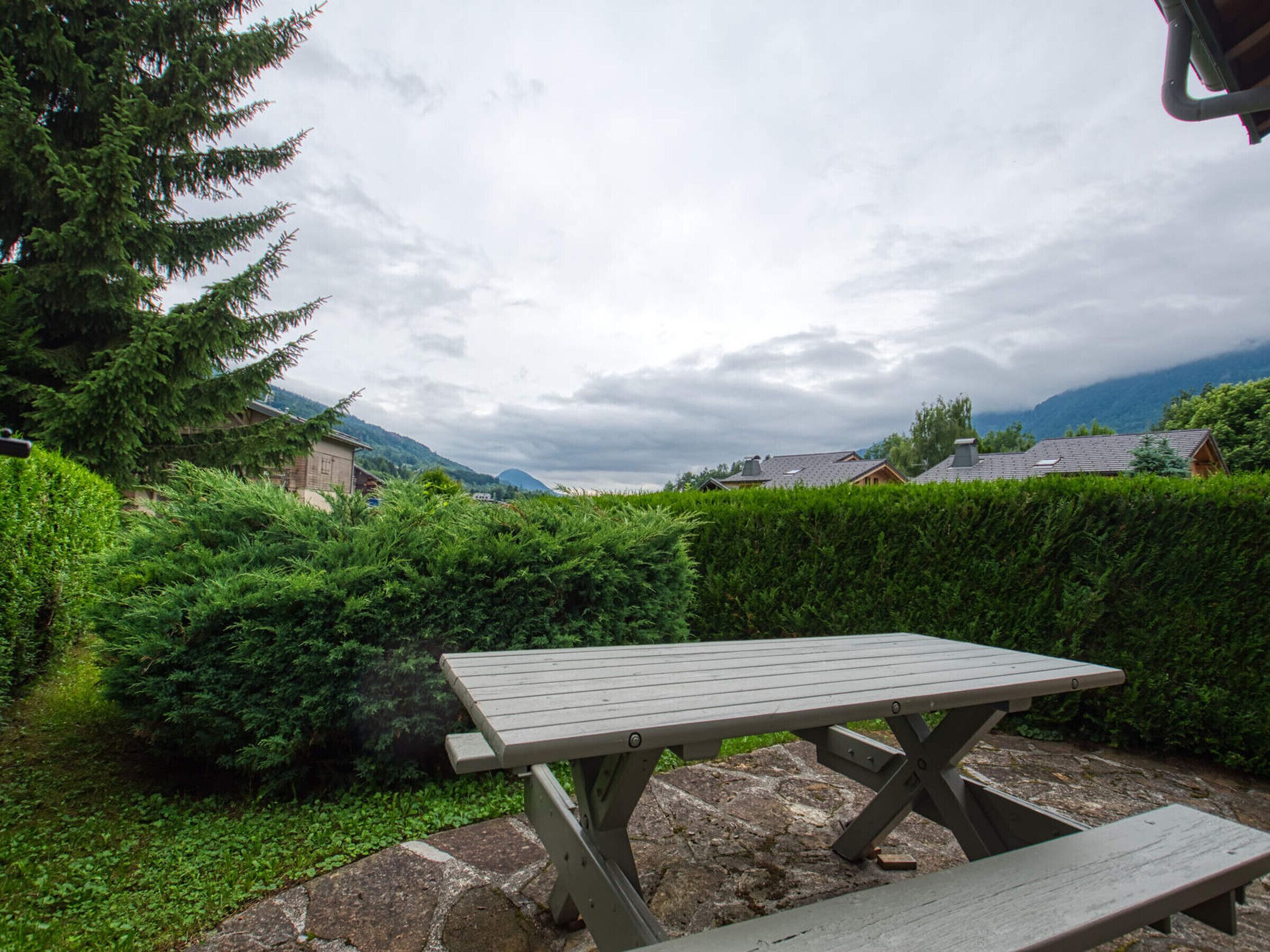 Ein Picknicktisch in einem Garten mit Blick auf Häuser und Berge.