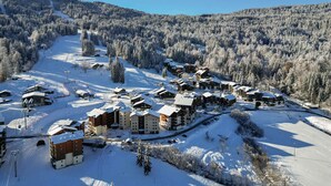A snow-covered ski resort with multiple lodges, ski lifts, and a clear view of the surrounding forested mountains. - Charming 6-person apartment, balcony with mountain view, modern comfort, non-smoking (Morillon 1100)