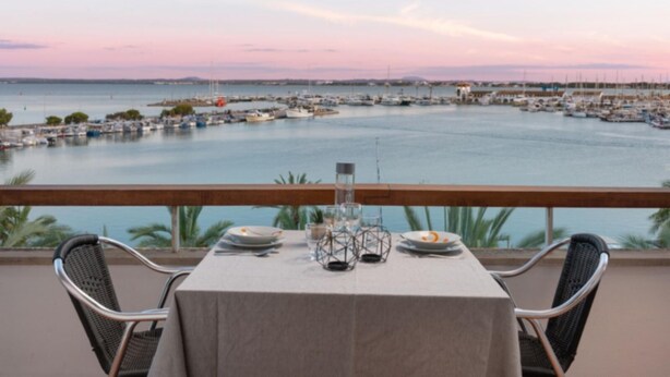 Ein Tisch für zwei Personen mit Blick auf eine Marina und Boote.