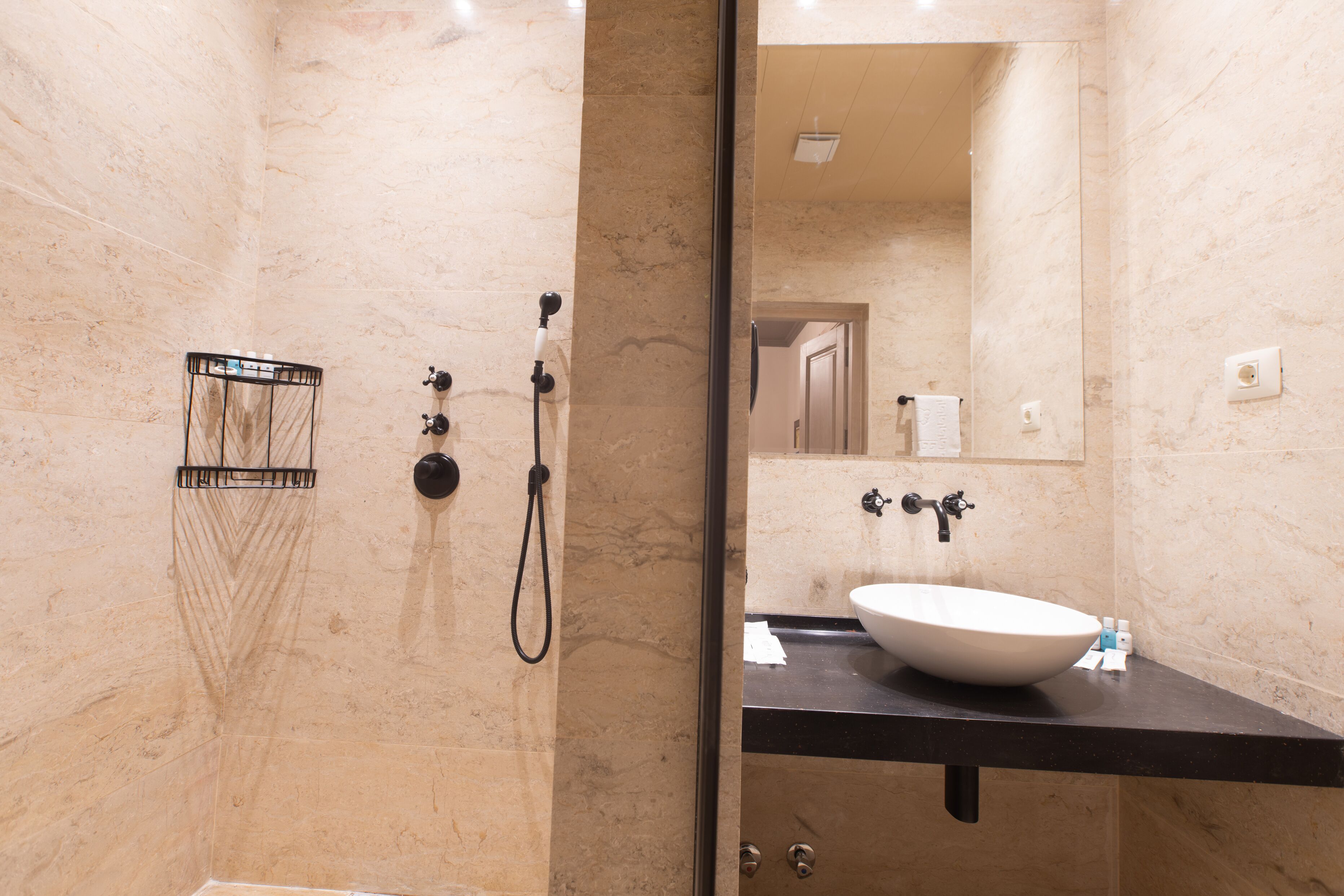 Un baño moderno con un espejo grande, un lavabo blanco y una zona de ducha.