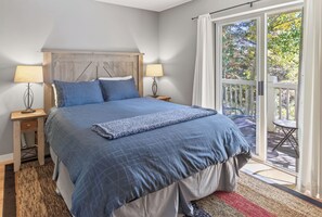 A bedroom with a bed, two bedside tables, a window with curtains, and a view of the outdoors. - Nice Updated Condo. Hot Tub. Access to Lake. (Frisco)