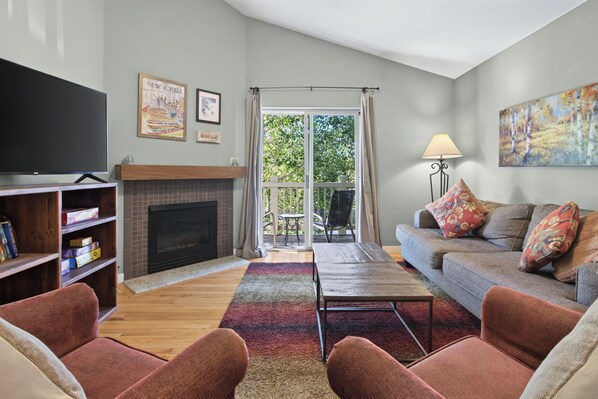A living room with a fireplace, a television, and a sofa. - Nice Updated Condo. Hot Tub. Access to Lake. (Frisco)