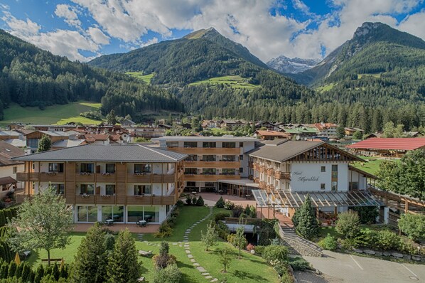 A hotel with multiple floors, a courtyard, and a mountain backdrop.