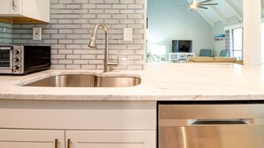 A modern kitchen with a stainless steel sink, a built-in dishwasher, and a toaster oven.