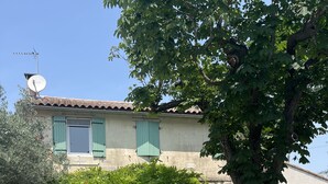 A two-story house with a tiled roof, green shutters, and a satellite dish. - mas (Tarascon)