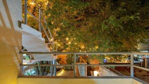 A staircase with a metal railing leading to a lower level, surrounded by lush greenery and string lights. - 🌿🌿 Tamarind 4 (Durango)