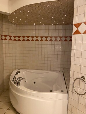 Een bad, een bubbelbad, een haardroger, handdoeken