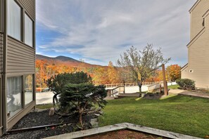 A residential building with a view of autumn foliage and a distant mountain range.