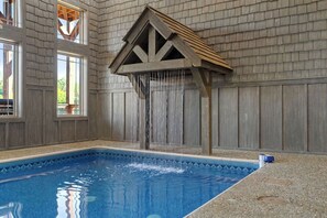 Ein Hallenbad mit Holzwänden und einer Holzkonstruktion darüber.