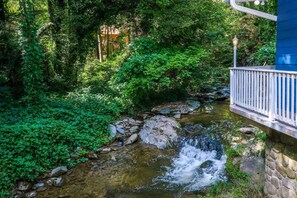 Escape to a serene natural oasis with a tranquil stream and lush surroundings.