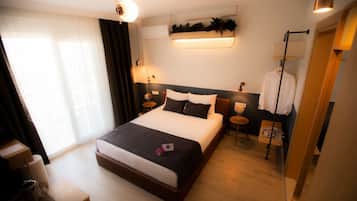 A hotel room with a large bed, bedside tables, a desk, and a mirror.
