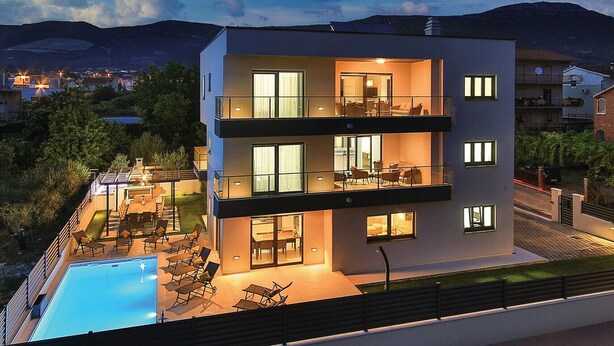 A modern multi-story building with a swimming pool, outdoor seating, and balconies. - Luxury Dream House in Kaštel Novi (Kaštel Novi)