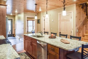 A kitchen with wooden cabinets, a granite countertop, and a built-in dishwasher.