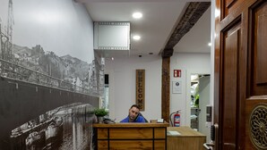 A reception desk with a "CAUSAL" sign, a cityscape mural, and a wooden floor. - Casual Bilbao Mardones (Bilbao)