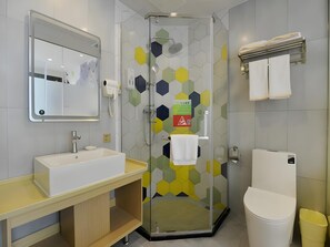 Ein modernes Badezimmer mit Duschkabine, Waschbecken, Toilette und Handtuchhalter.