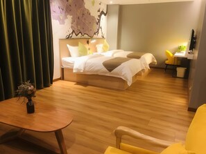 A modern hotel room with a large bed, a desk, and a chair.