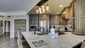 A kitchen with a marble island, stainless steel appliances, and pendant lighting. - 2112 SeaCrest -Stunning Villa offers Lowcountry luxury living! (Hilton Head Island)