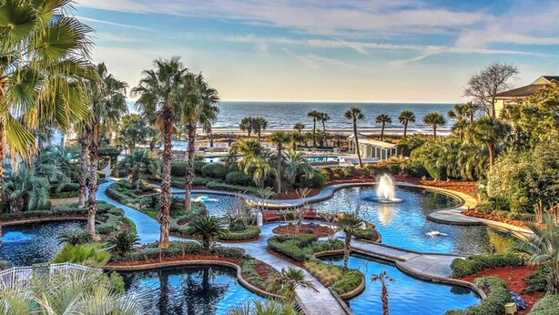 A resort with multiple swimming pools, palm trees, and a view of the ocean. - 2112 SeaCrest -Stunning Villa offers Lowcountry luxury living! (Hilton Head Island)