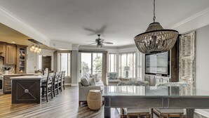 A spacious kitchen with wooden cabinets, a dining area with a glass table, and a large chandelier. - 2112 SeaCrest -Stunning Villa offers Lowcountry luxury living! (Hilton Head Island)