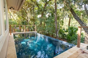A swimming pool surrounded by lush greenery and trees.