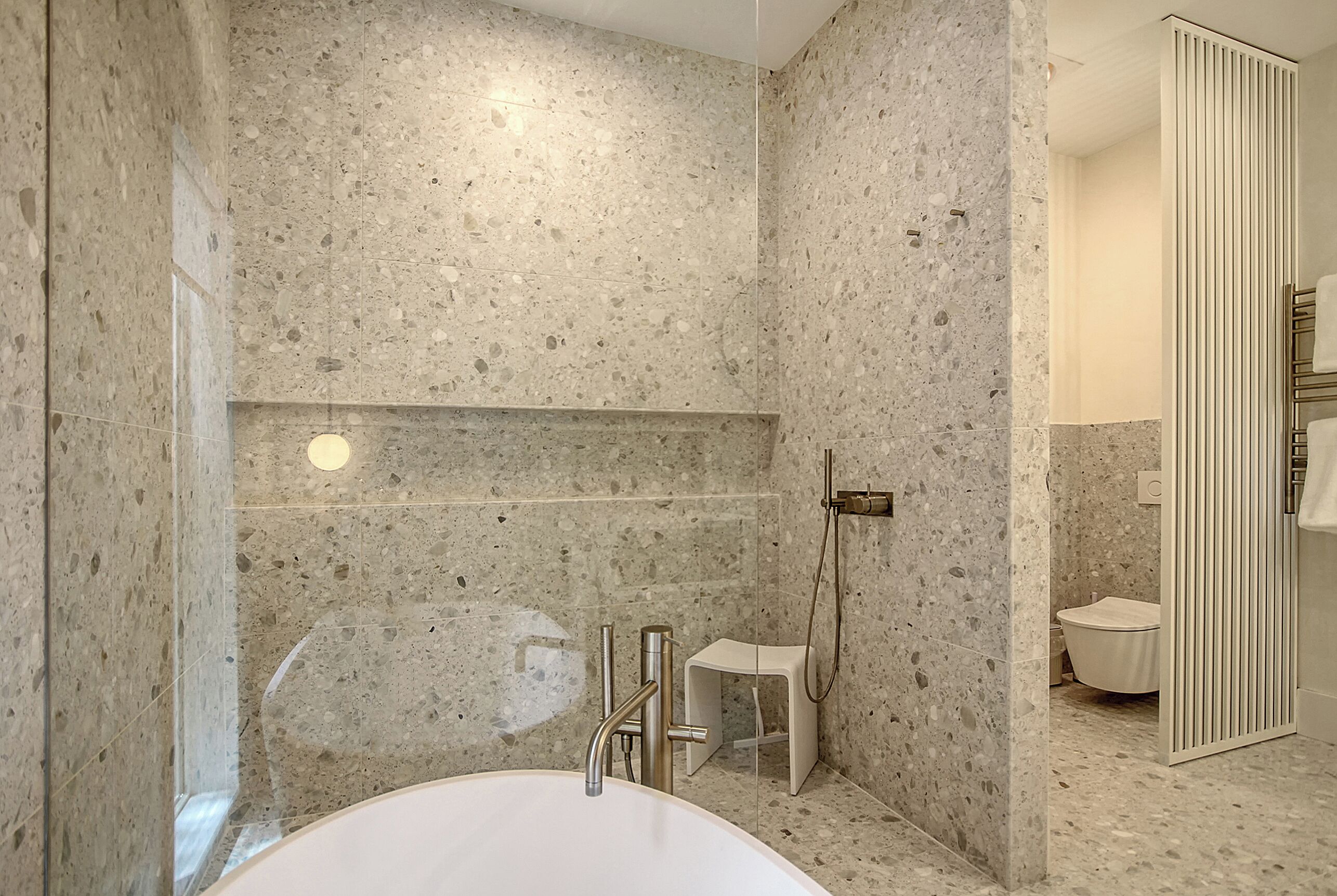 Une salle de bain moderne avec une baignoire sur pieds, une douche et des toilettes.