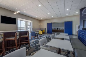 A modern hotel lobby with a bar area, seating arrangements, and a large window providing a view. - Hawthorn Extended Stay by Wyndham Wichita Airport (Wichita)