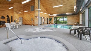 Une piscine intérieure dotée de plusieurs couloirs de nage, d’espaces pour s’asseoir et d’un décor intérieur en bois.